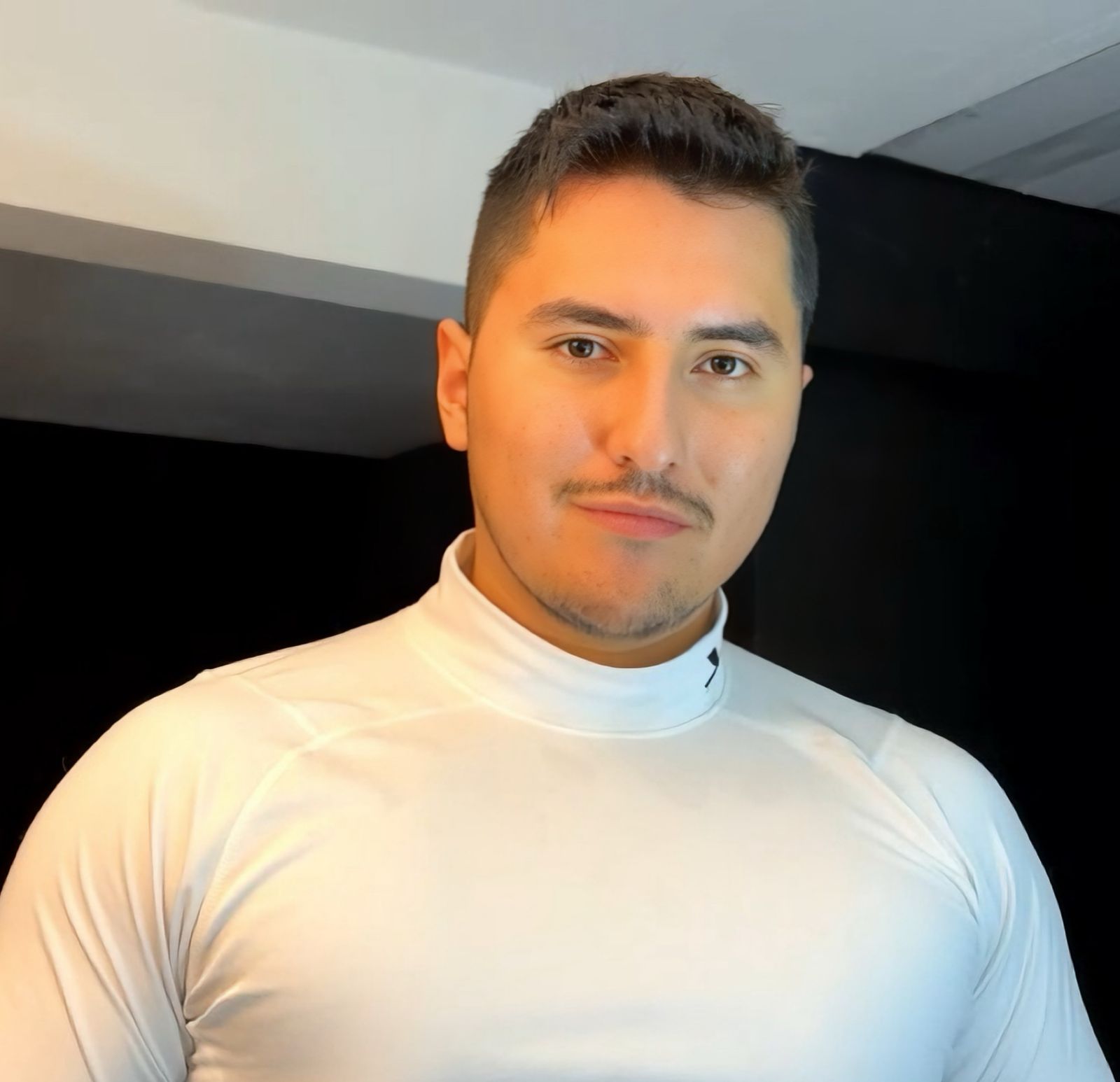 Foto profesional de Andrés Ángel, hombre con fondo neutro, sonriendo, con camisa blanca y fondo claro